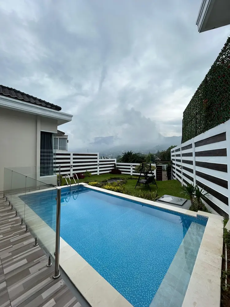 Private pool beside the villa under a cloudy mountain sky at Nirvana Villas