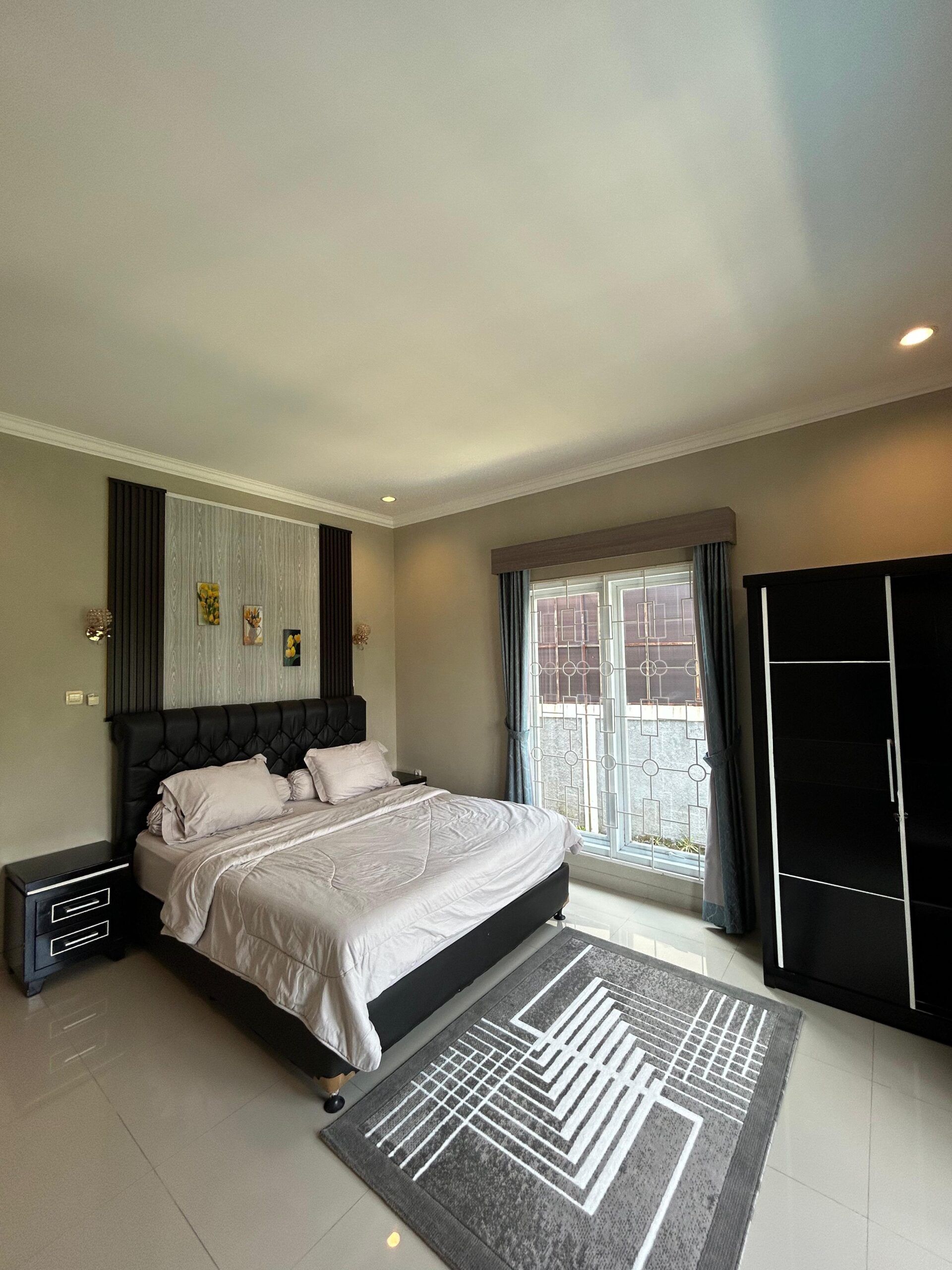 King bed with patterned rug and bedside table