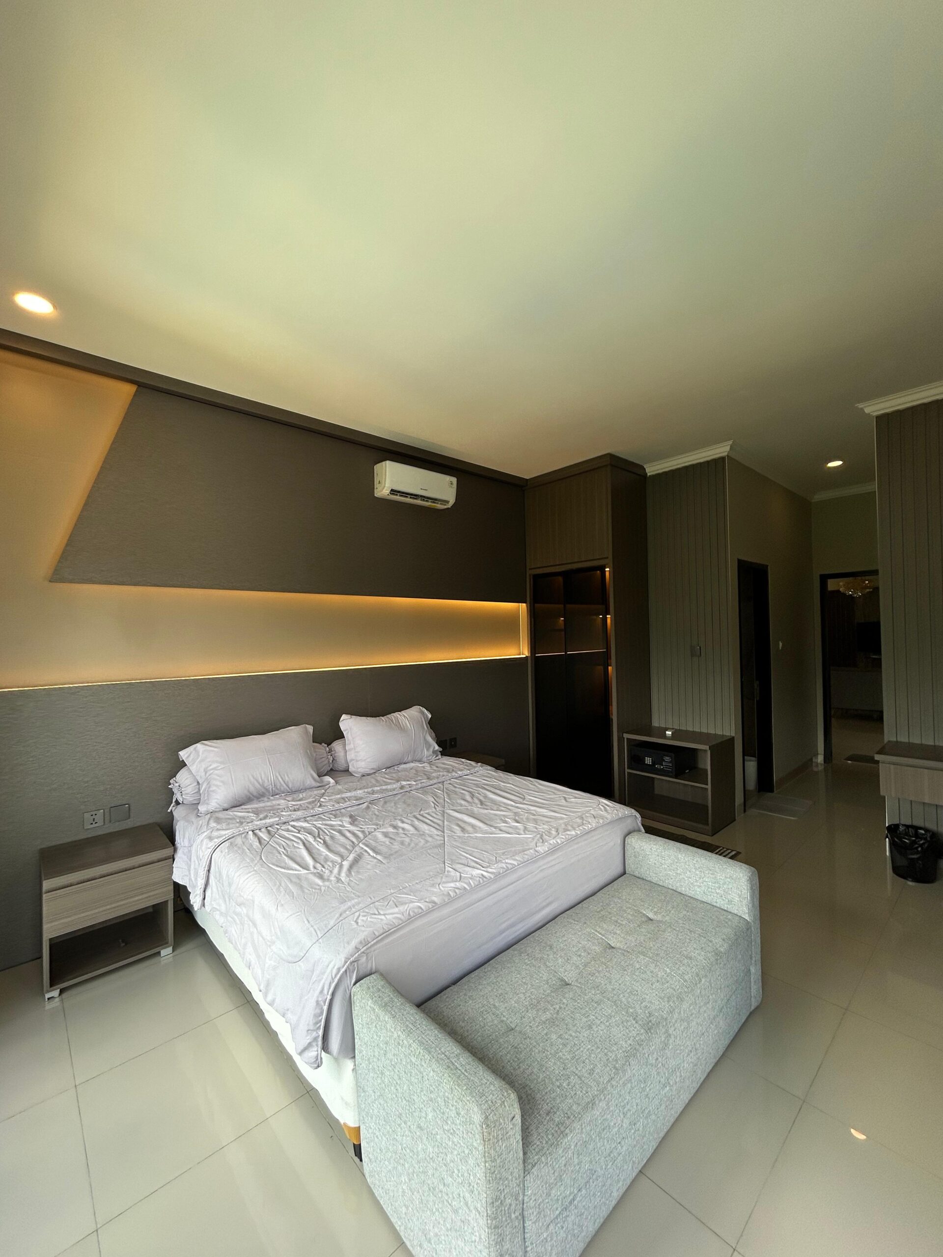 King bed with bench seat and warm lighting