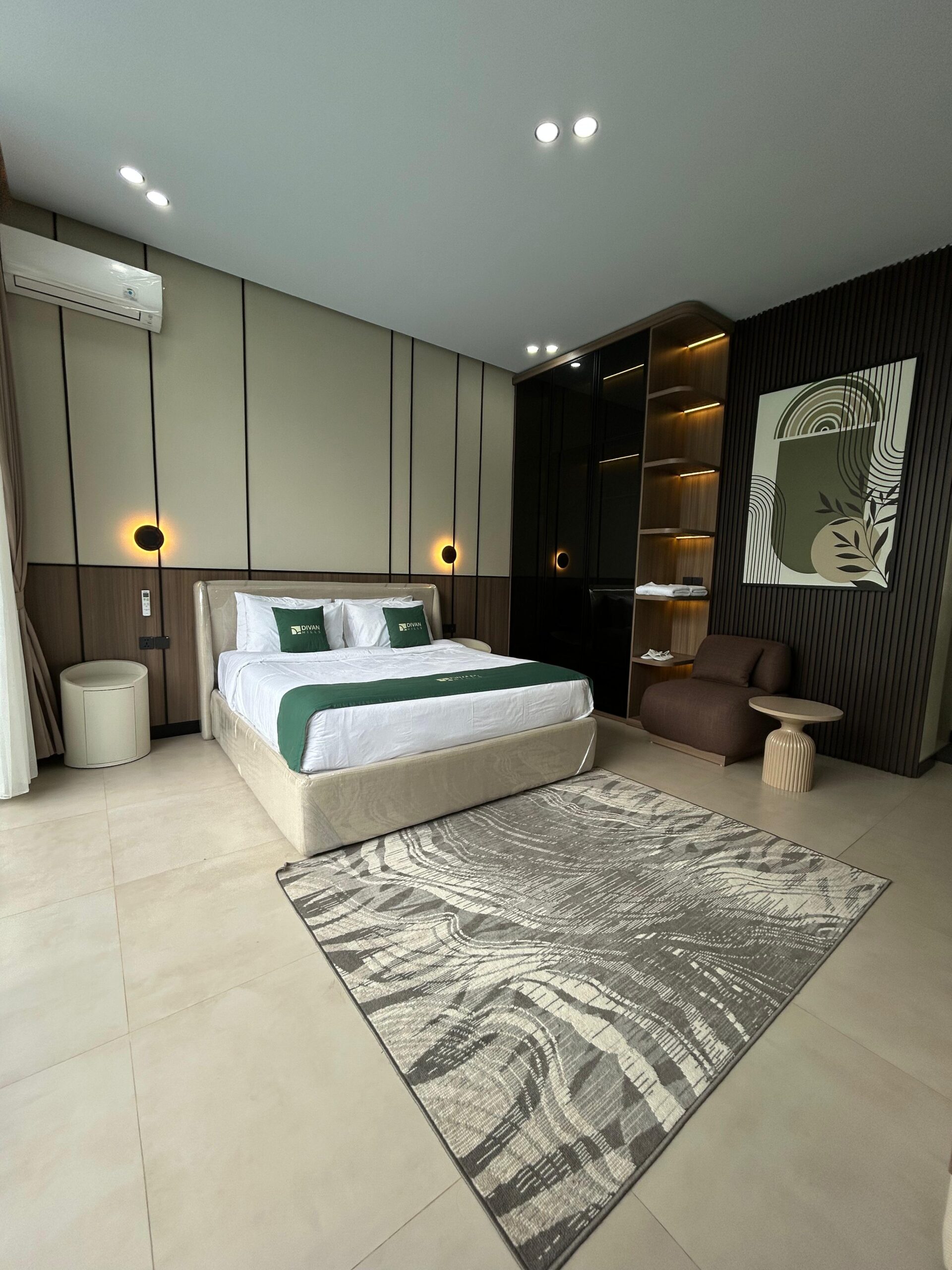 King bed with green throw and patterned rug