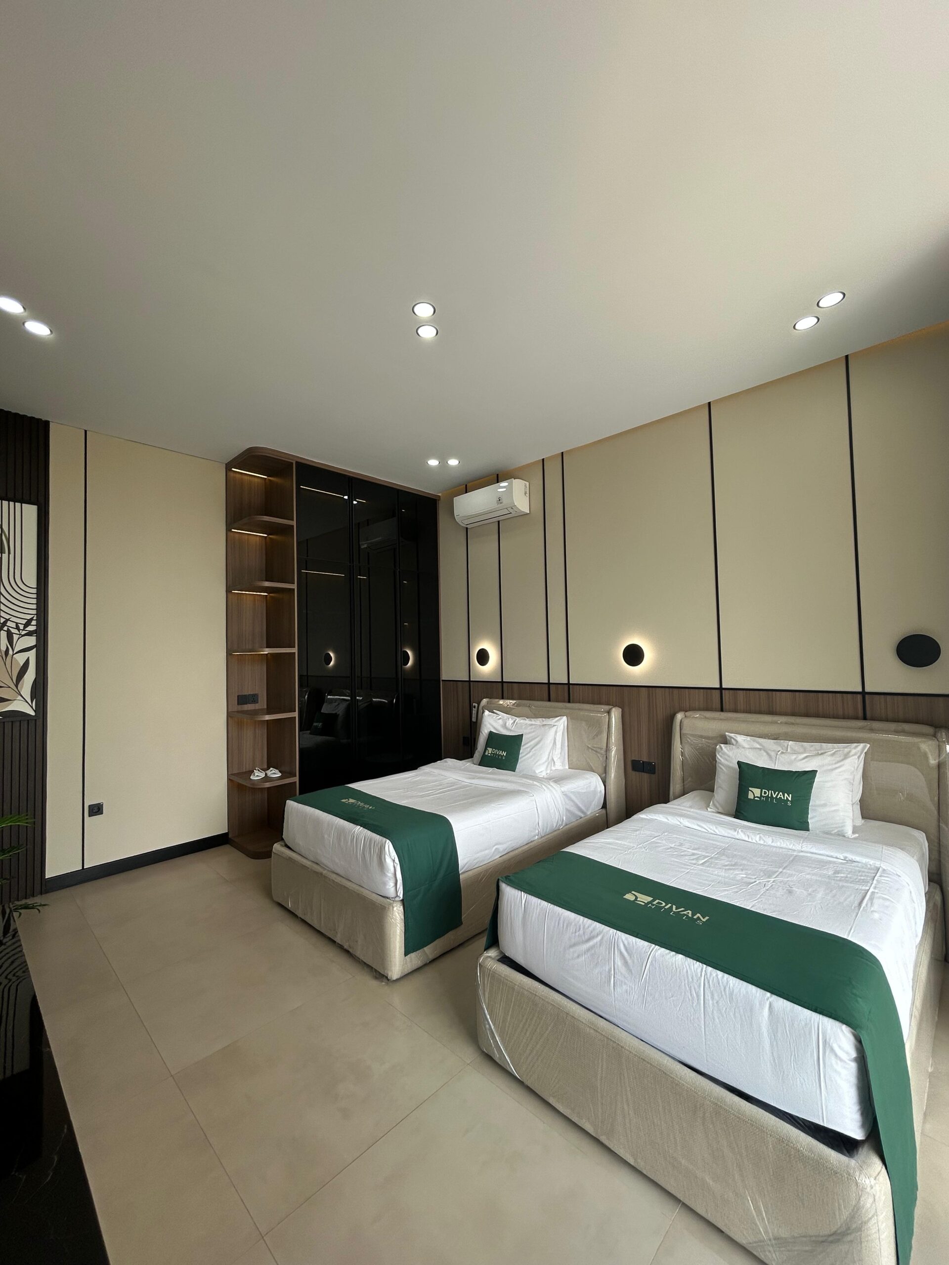 Twin beds with green throws and fitted wardrobe