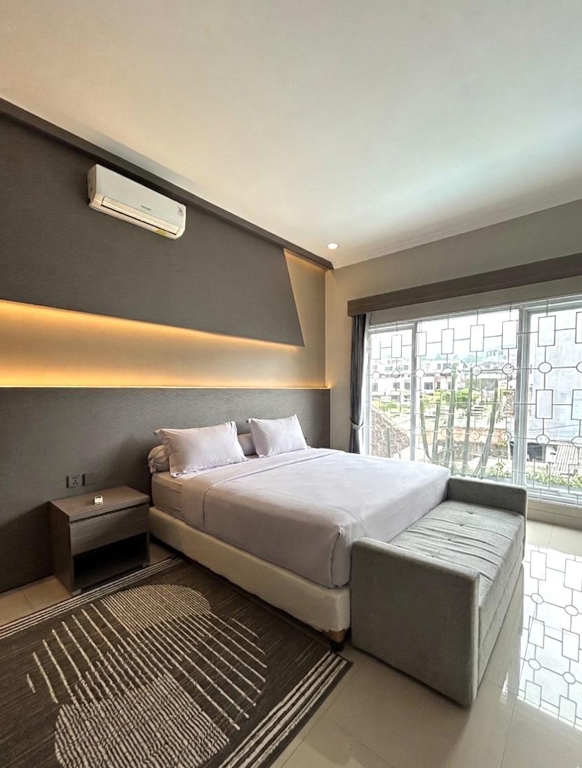 King bed with bench seat and window view